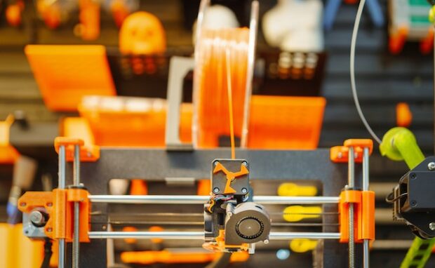 Image illustrating a 3D printer in action, creating a physical object layer by layer.